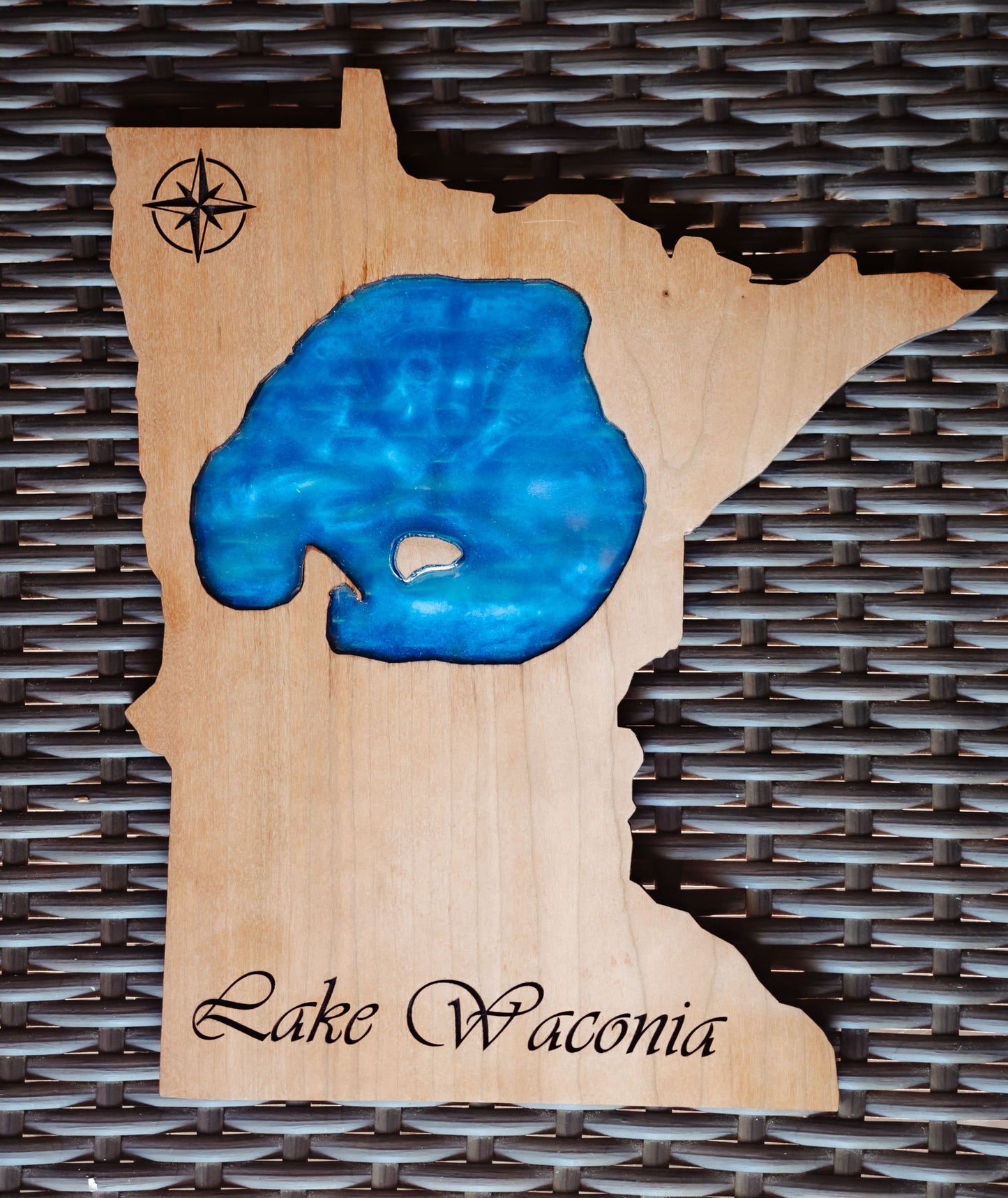 A wooden plaque shaped like the state of Minnesota, featuring a glossy blue resin inlay representing Lake Waonia and the word 'Lake Waonia' engraved at the bottom