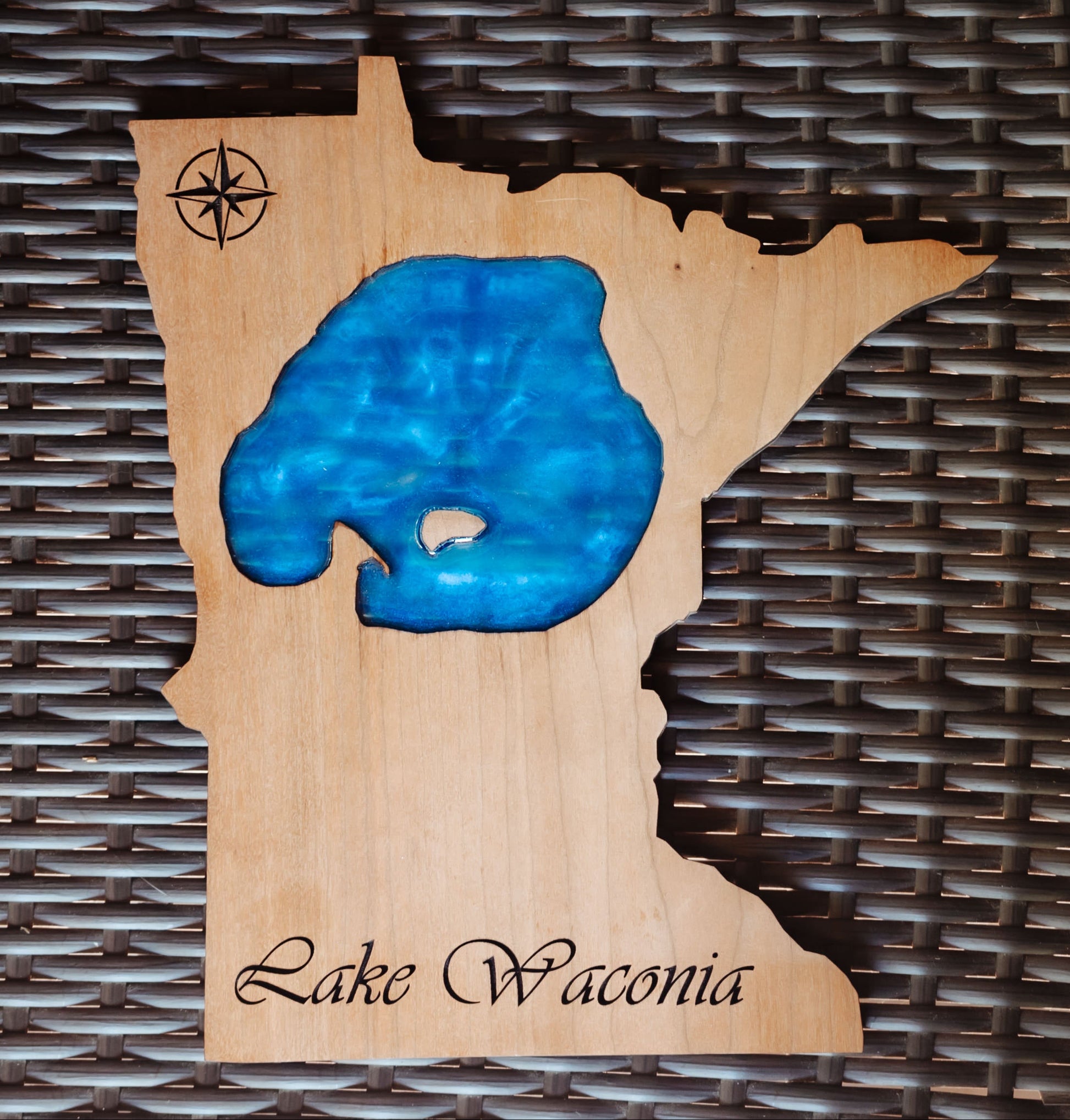 A wooden wall art piece shaped like the state of Minnesota, featuring a blue resin Lake Waonia fill and engraved script reading 'Lake Waonia' at the bottom